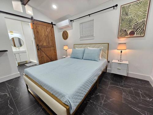 a bedroom with a bed with two lamps and a door at Comfy Tiny Home WP Large Private Deck Queen bed in Orlando
