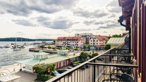 a balcony with a view of a river and buildings at Waxholms Hotell in Vaxholm