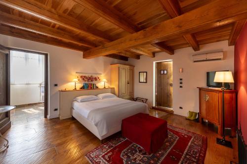a bedroom with a large white bed and a television at Villa Tiboldi in Canale