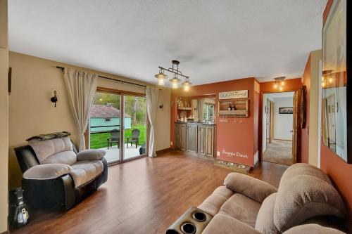 a living room with two couches and a kitchen at Fowl Play Hideaway in Michigan City