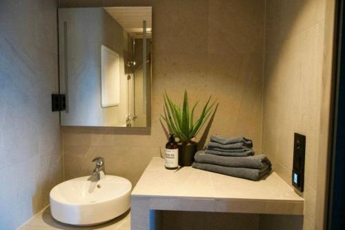 a bathroom with a sink and a toilet and a mirror at Seafront apartment Henningsvær in Henningsvær