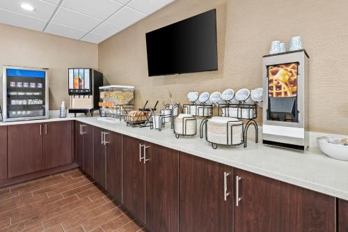 a room with a bar with a tv on the wall at Comfort Inn & Suites Oxford South in Oxford