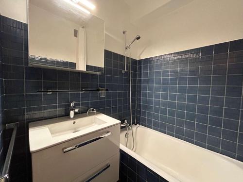 een blauw betegelde badkamer met een wastafel en een bad bij Studio 2/4 pers, Accès Pistes et Piscine, Proche Commerces, Méribel - FR-1-180-297 in Méribel