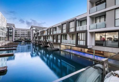 an apartment building with a swimming pool in front of it at QV Stays Modern City Retreat in Auckland