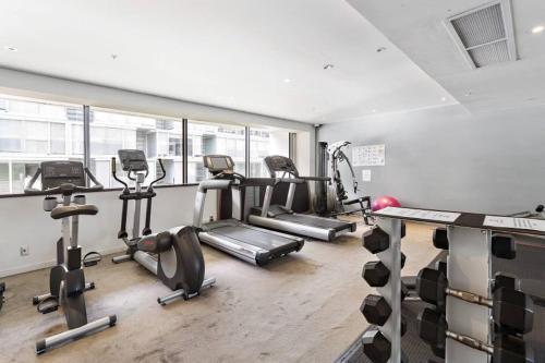 a gym with treadmills and cardio machines in a room at QV Stays Modern City Retreat in Auckland