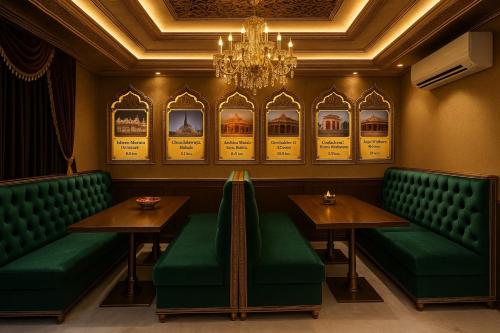 a restaurant with green booths and tables and a chandelier at Tata Vista Resort, Vrindavan - #big swimming pool #luxury rooms #gardens #playing zone #away from city hustle # BY ELEGANCE GROUP# in Vrindāvan