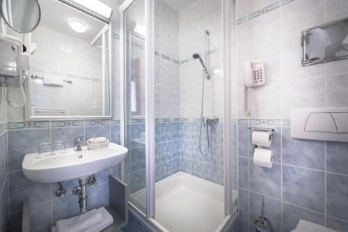 uma casa de banho com um chuveiro, um lavatório e um WC. em Zvonimir Sunny Hotel em Baška