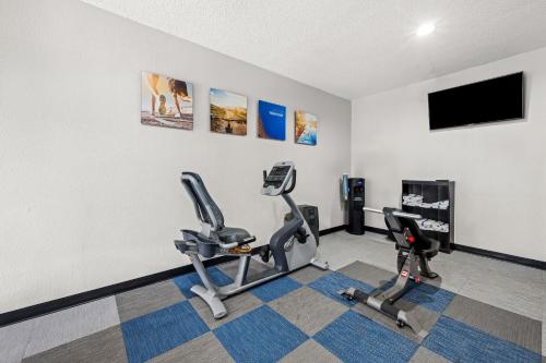 a gym with two exercise bikes and a flat screen tv at Comfort Inn & Suites Oxford South in Oxford