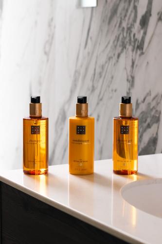 three bottles of soap sitting on a bathroom counter at Orange Grove Hotel & Gardens in Southampton
