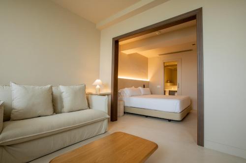 a living room with a couch and a bed in a room at Les Clarisses Boutique Hotel in Vic