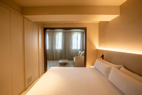 a bedroom with a white bed and a window at Les Clarisses Boutique Hotel in Vic
