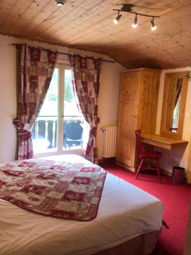 a bedroom with a bed and a large window at Hôtel la Kinkerne in Morzine