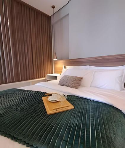 a bedroom with a large bed with a tray on it at Loft Moderno perto da Faculdade in Mogi das Cruzes