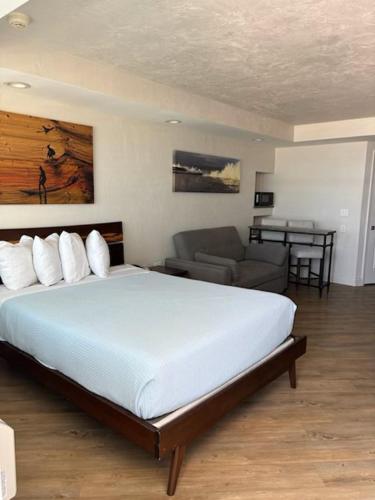 a bedroom with a large bed and a couch at Georgian Inn Beach Club in Ormond Beach