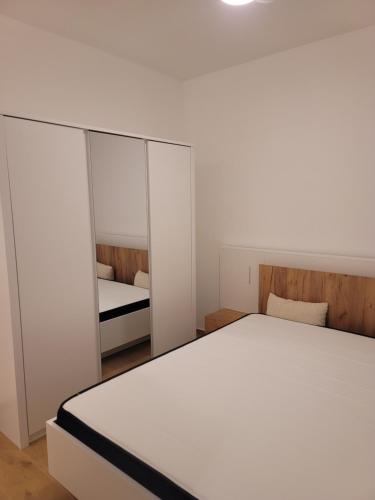 a bedroom with a white bed and a mirror at Merysuite Campomarino lido in Campomarino