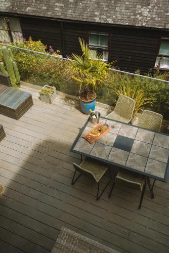 a patio with a table and chairs on a deck at Merthen House in Falmouth