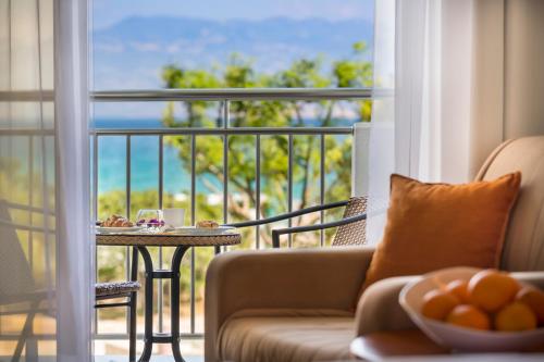a living room with a couch and a balcony with a table at Sunny Baška Residence by Valamar, ex Zvonimir in Baška