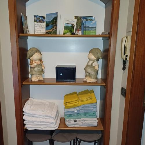 a book shelf with two dolls and towels at B&B Miele in San Fermo della Battaglia