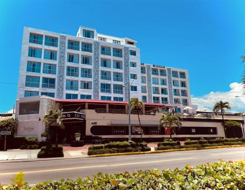 a bus is parked in front of a large building at Napolitano Hotel in Santo Domingo