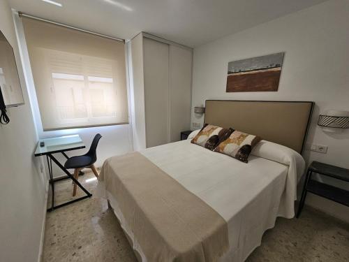 a bedroom with a bed and a desk and a window at Apartamento Reyes Católicos in Córdoba