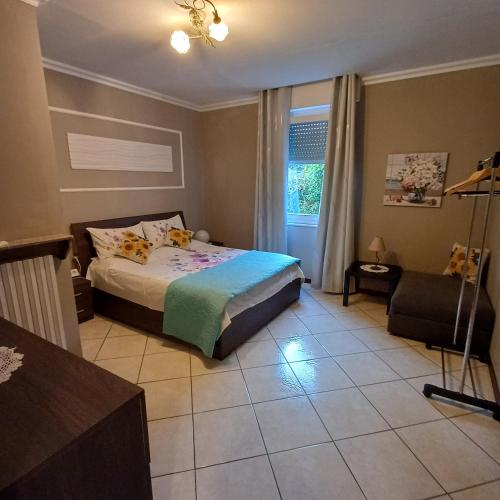 a bedroom with a bed and a chair and a window at B&B Miele in San Fermo della Battaglia