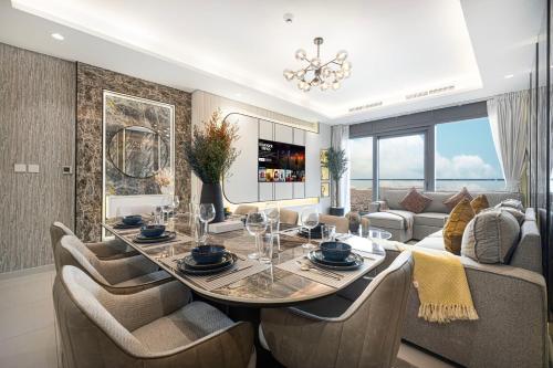a dining room with a table and a couch at Paramount Residences Dubai Apartments by BergStays in Dubai