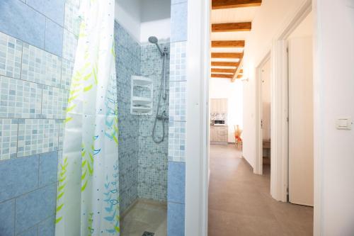 baño con paredes de azulejos azules y ducha. en Tenuta Doret, en Taviano