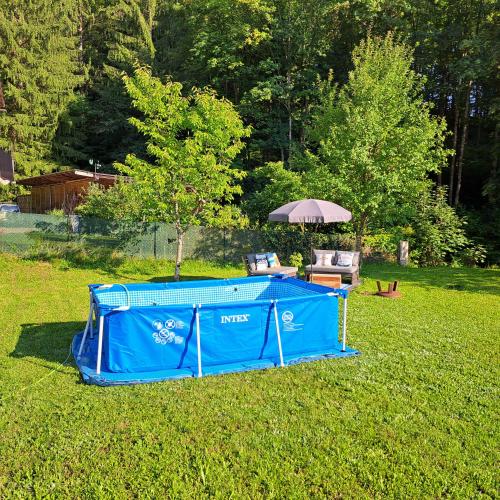 a blue tent in a field with an umbrella at Haus Am Schloss in Bleiburg