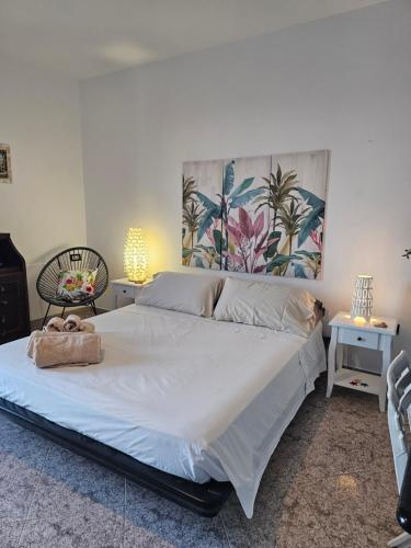 a bedroom with a large white bed with two tables at Alba di Mare - Appartamento con Vista Mare in Andrano
