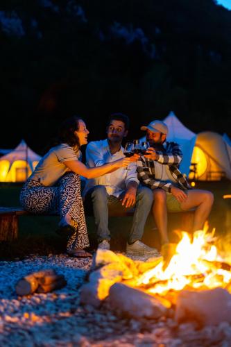 a group of people sitting around a fire at Glamping Gozdna Jasa in Bovec