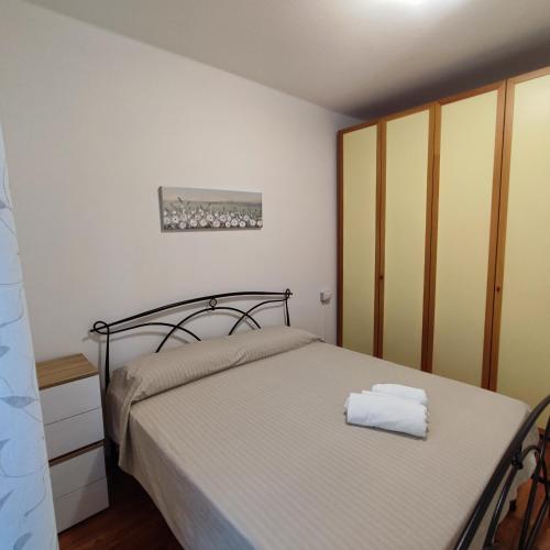 a bedroom with a bed with a white bedspread at Appartamento Stella in Sondrio