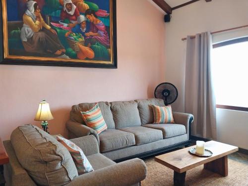 a living room with a couch and a painting on the wall at Playa Flamingo penthouse with pacific sunset views - Flamingo Rose Vista in Playa Flamingo