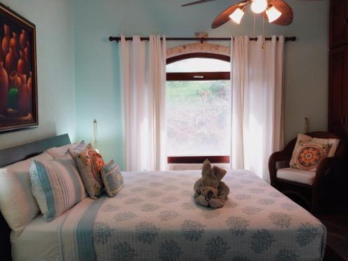 a stuffed animal sitting on a bed in a bedroom at Playa Flamingo penthouse with pacific sunset views - Flamingo Rose Vista in Playa Flamingo