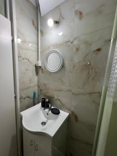 a bathroom with a sink and a mirror at Apartman Boža 1 in Kuršumlija