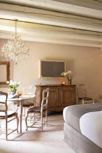 a bedroom with a table and a bed and a chandelier at Maison Benedictine in Caprino Veronese