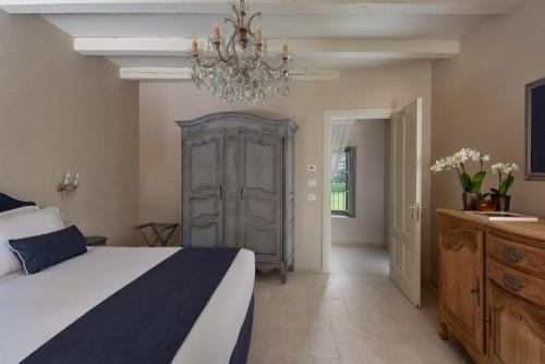 a bedroom with a large bed and a chandelier at Maison Benedictine in Caprino Veronese
