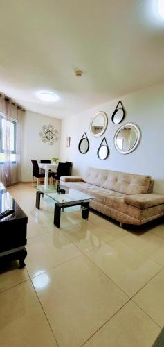 a living room with a couch and mirrors on the wall at See Of Galilee 510 in Tiberias