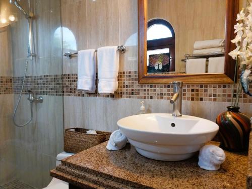 a bathroom with a sink and a mirror and a shower at Playa Flamingo penthouse with pacific sunset views - Flamingo Rose Vista in Playa Flamingo