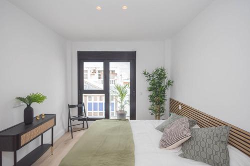 une chambre avec un lit, un bureau et une fenêtre dans l'établissement 3BR Portview Luxury Penthouse & Terrace, à Las Palmas de Gran Canaria