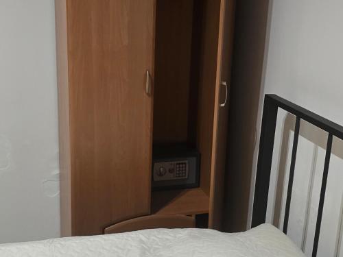 a room with a bed and a cabinet with a clock at Wagner's Refuge 2 in Rīga