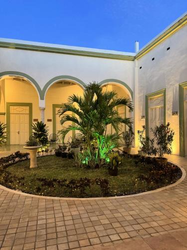 a building with a courtyard with palm trees in it at Hotel Boutique La Casona by Kavia in Mérida