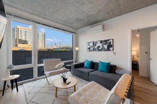 a living room with a couch and a large window at Chic 4-Bedroom with Skyline Views & Amenities in Chicago