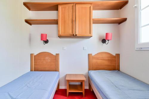 two twin beds in a room with two cabinets at Résidence Le Hameau du Lac - maeva Home - Appartement 2 pièces 4 personnes - Confort MAE-0524 in Marciac