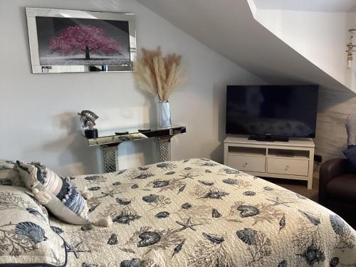 a bedroom with a bed and a tv in a room at By the Seaside in Blackpool