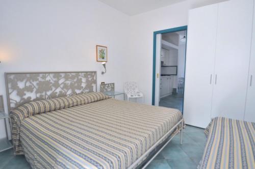 1 dormitorio con 1 cama con colcha a rayas en Residence del Mare, en Palinuro