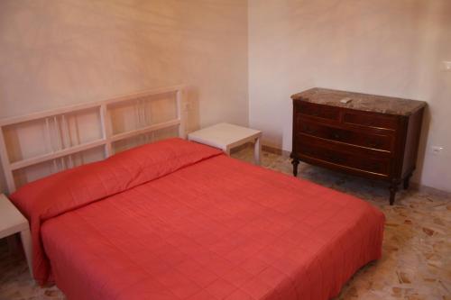 una camera da letto con un letto rosso e un comò di Appartamento Rifredi a Firenze