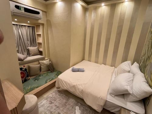 a small bedroom with a white bed and a window at شقة فندقية بالزمالك خلف فندق ام كلثوم اطلالة جانبية على النيل in Cairo