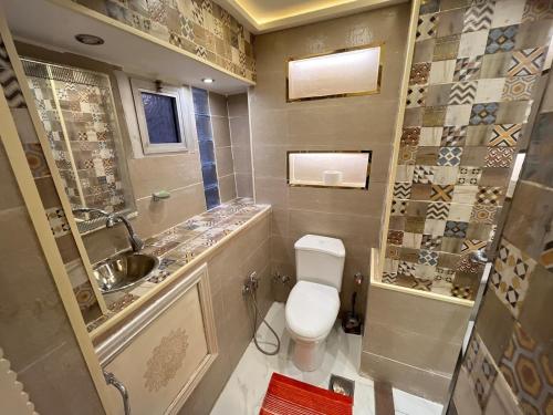a bathroom with a toilet and a sink at شقة فندقية بالزمالك خلف فندق ام كلثوم اطلالة جانبية على النيل in Cairo