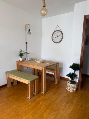 a room with a table and a clock on the wall at Dulce y sereno piso en Oviedo in Oviedo
