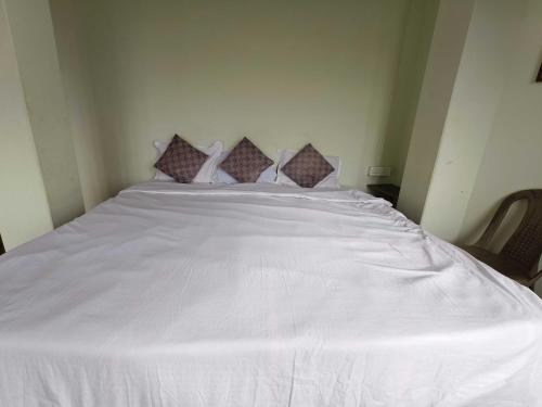 een groot wit bed met vier kussens erop bij Hotel O Sun View in Gangtok